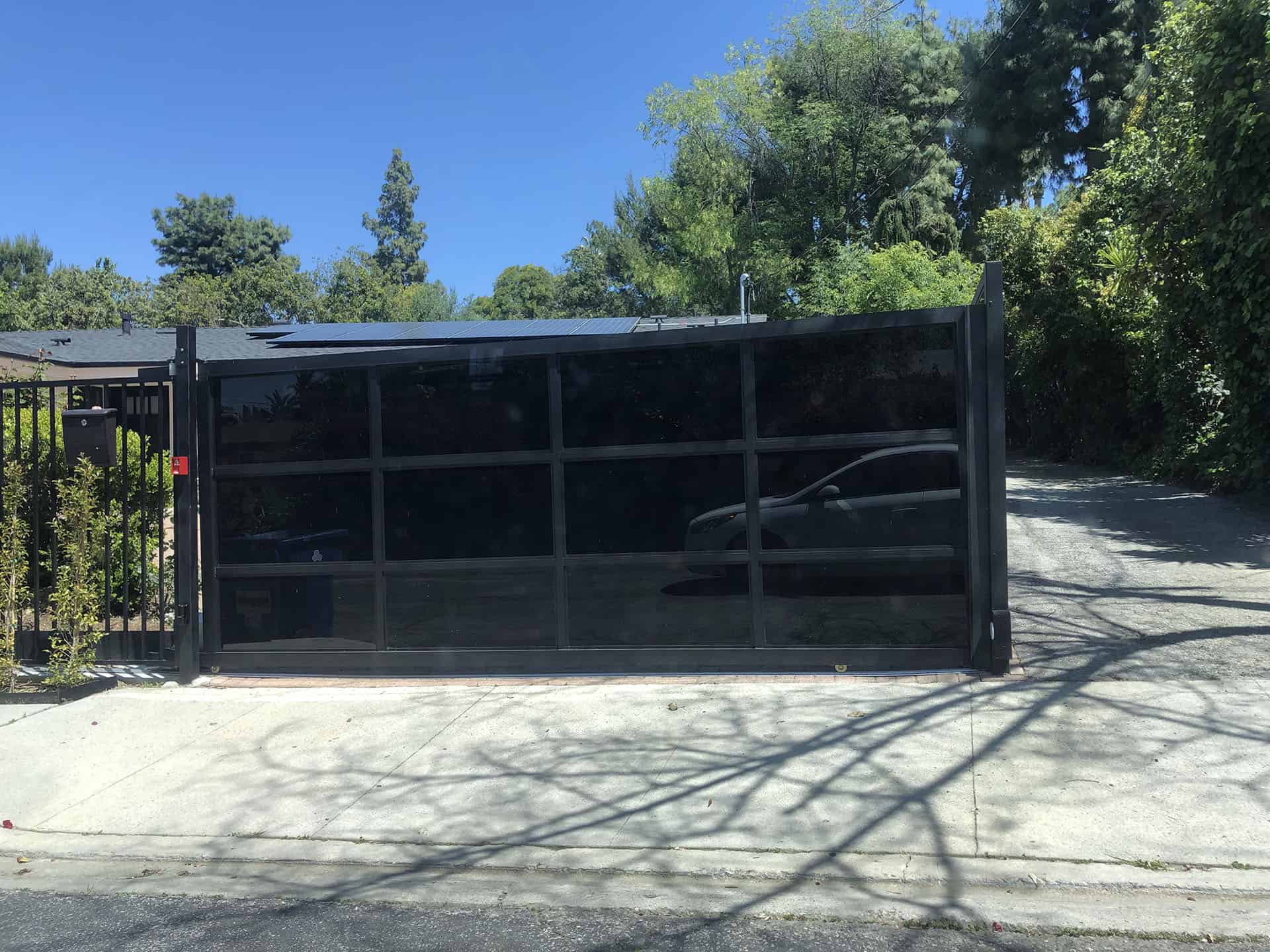 Black steel and glass sliding driveway gate