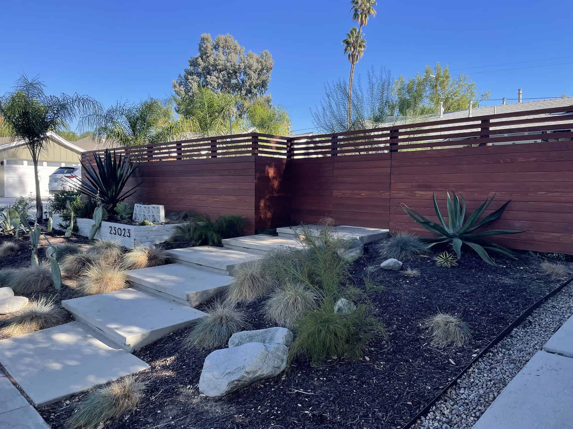 Modern redwood horizontal slat fence in a front yard