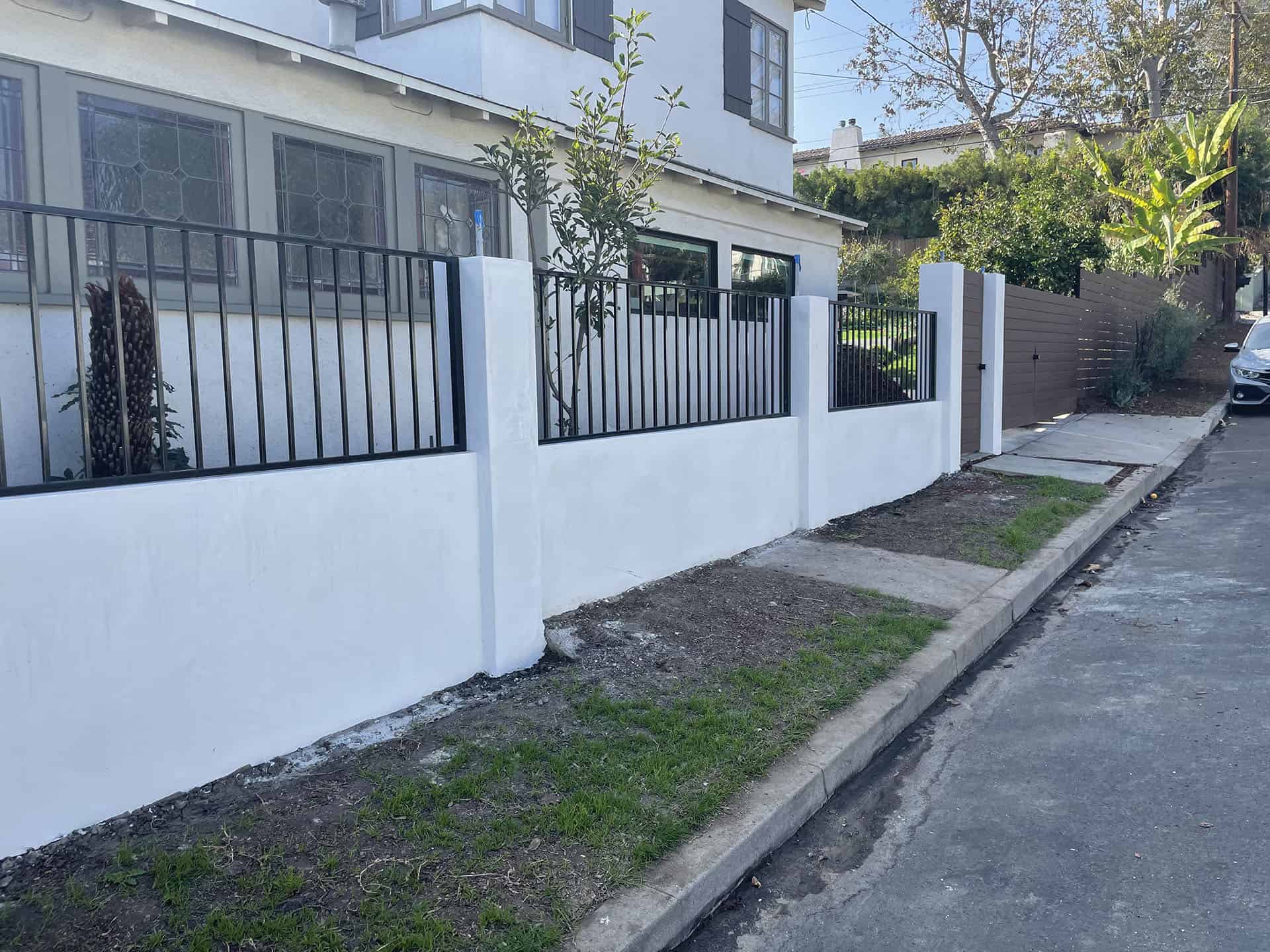 Wrought iron fence set into stucco pilasters